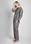 A woman wearing the woodblock print pajama set on a grey background.