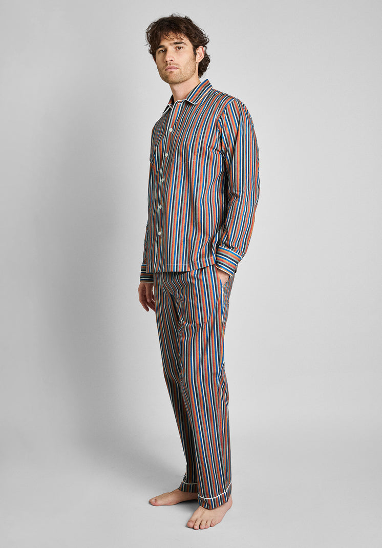 A man wearing the woodblock print striped pajama set on a grey background.