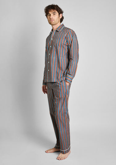 A man wearing the woodblock print striped pajama set on a grey background.