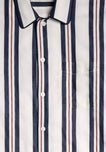 A detail image of an off-white pajama top featuring vertical red and navy nautical regimental stripes.