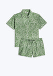 A green short sleeve pajama top with a white leaf print and a matching elastic-waist short in the same pattern.